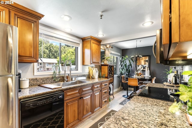 kitchen with sink, black appliances, light stone countertops, pendant lighting, and an inviting chandelier