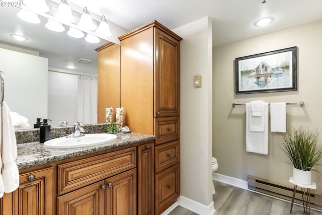 bathroom featuring hardwood / wood-style flooring, toilet, baseboard heating, vanity, and walk in shower