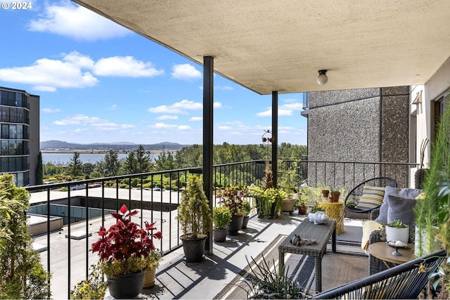 balcony featuring a water and mountain view