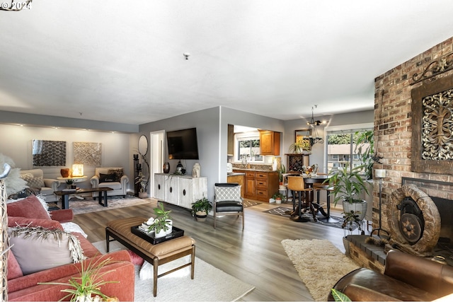 living room with a brick fireplace and light hardwood / wood-style floors