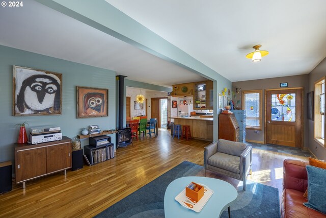 living room featuring light wood-type flooring, plenty of natural light, and beam ceiling