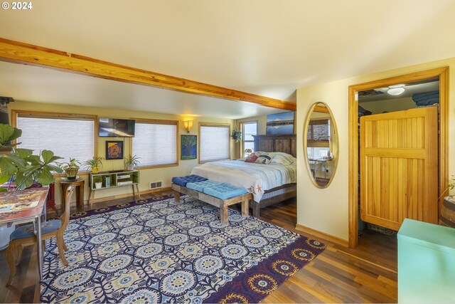 bedroom featuring beamed ceiling and hardwood / wood-style flooring