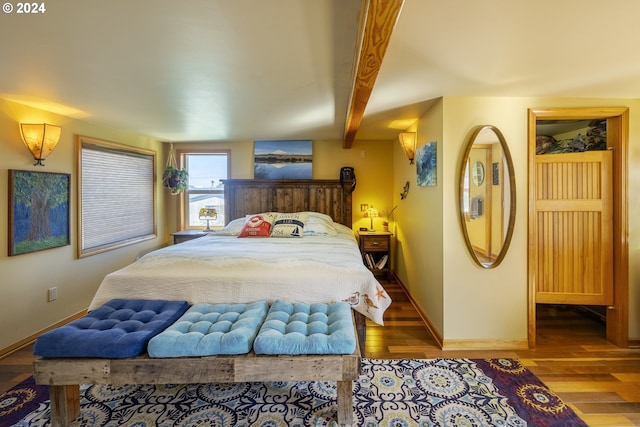 bedroom featuring beamed ceiling and hardwood / wood-style flooring