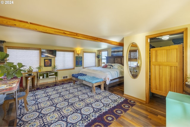 bedroom with beam ceiling and dark hardwood / wood-style flooring