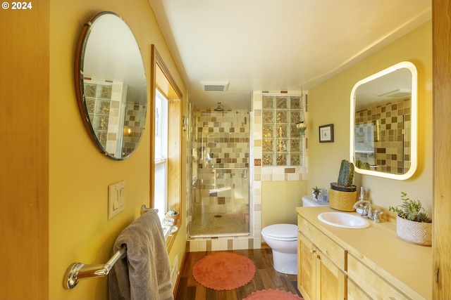 bathroom with vanity, hardwood / wood-style flooring, walk in shower, and toilet