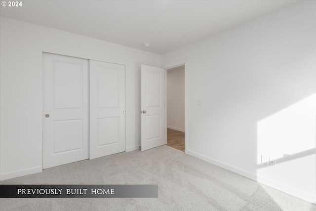 unfurnished bedroom featuring a closet, carpet flooring, and baseboards