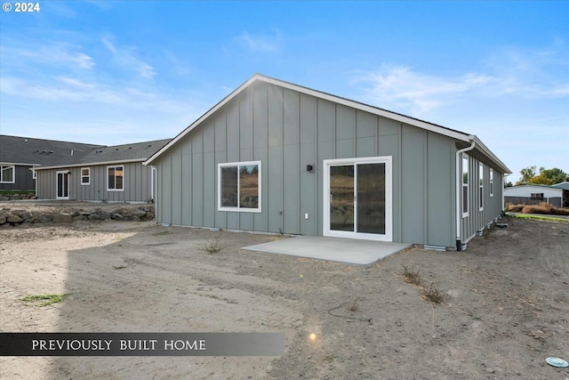 rear view of property with a patio and board and batten siding