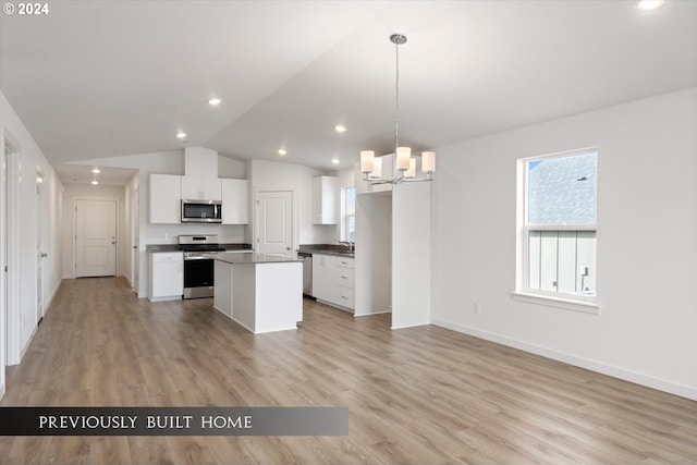 kitchen featuring a chandelier, stainless steel appliances, white cabinetry, a center island, and dark countertops