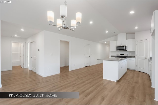 kitchen featuring white cabinets, lofted ceiling, a center island, stainless steel appliances, and light wood-type flooring