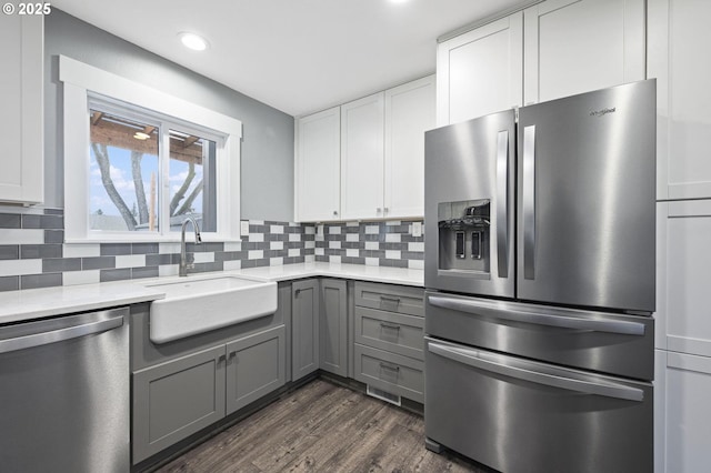 kitchen featuring sink, backsplash, stainless steel appliances, and white cabinets