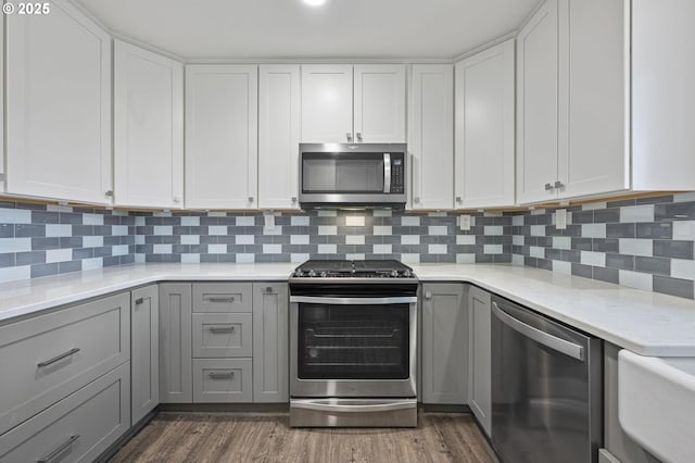 kitchen with white cabinetry, appliances with stainless steel finishes, and gray cabinets