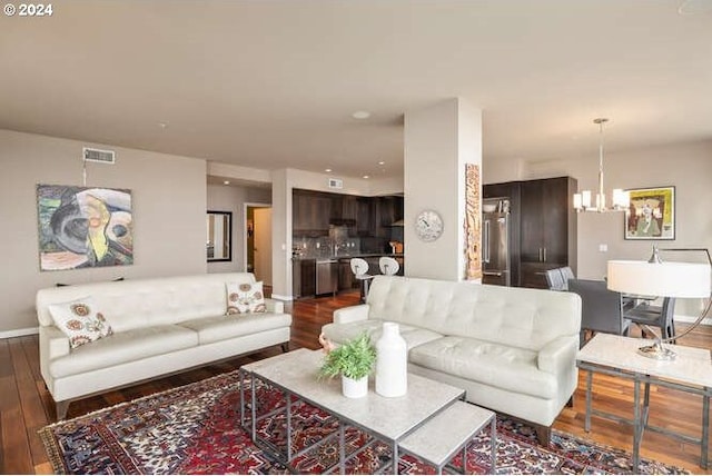 living room with dark hardwood / wood-style floors and an inviting chandelier