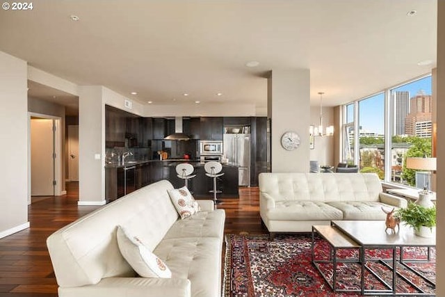 living room featuring a wall of windows, baseboards, dark wood-type flooring, and a chandelier