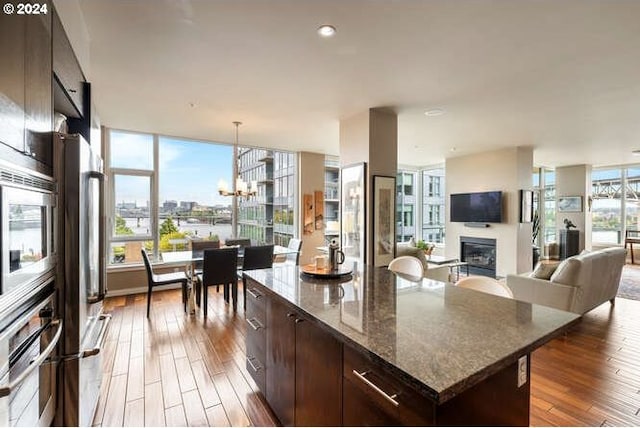 kitchen featuring dark brown cabinetry, dark hardwood / wood-style floors, a kitchen island, and a notable chandelier