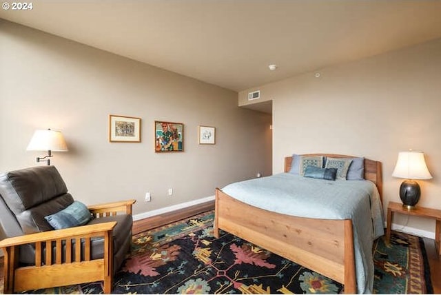 bedroom featuring wood finished floors, visible vents, and baseboards