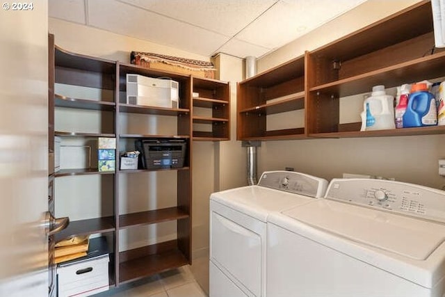 laundry room with washer and clothes dryer and light tile patterned floors