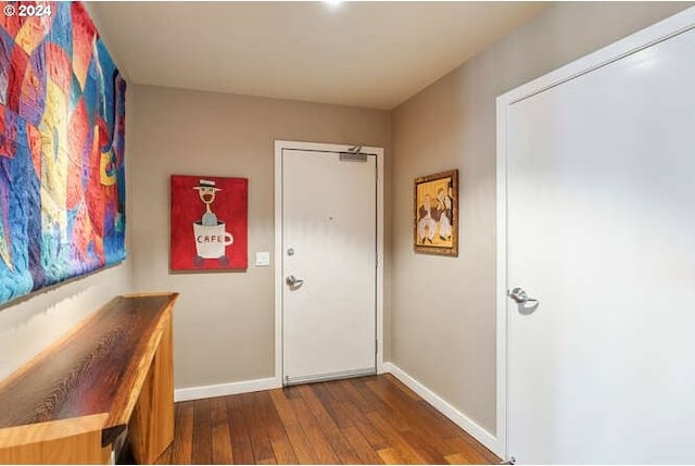 foyer entrance with dark wood finished floors and baseboards