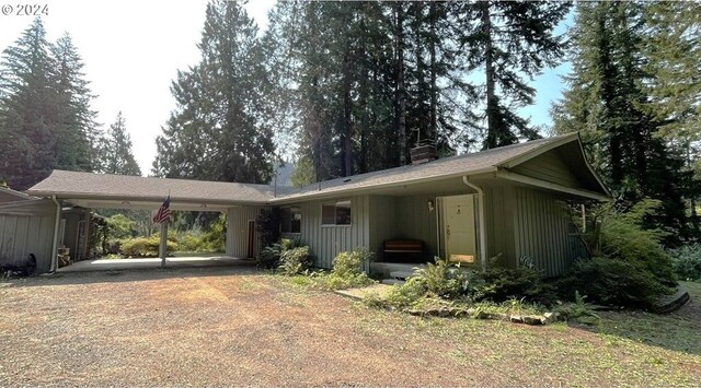 87535 Tiernan Rd, Mapleton, OR 97453 - single story home with a chimney, an attached carport, board and batten siding, and dirt driveway