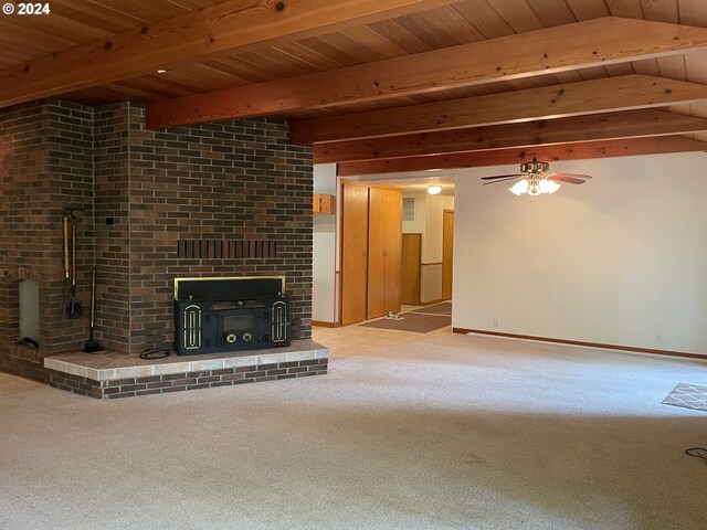 87535 Tiernan Rd, Mapleton, OR 97453 - unfurnished living room featuring beam ceiling, carpet flooring, a ceiling fan, a wood stove, and baseboards