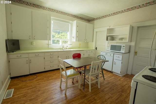 kitchen with sink, white cabinetry, white appliances, backsplash, and dark wood-type flooring