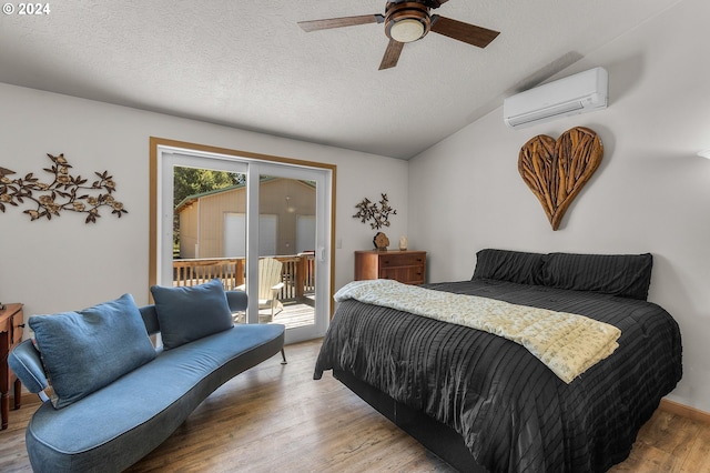 bedroom with ceiling fan, light hardwood / wood-style floors, an AC wall unit, and access to outside