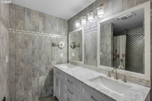 bathroom with curtained shower, vanity, and tile walls