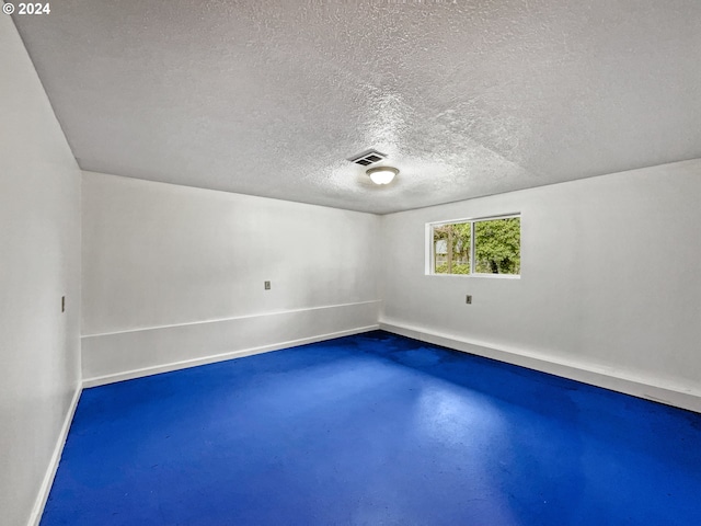 unfurnished room featuring a textured ceiling and concrete flooring