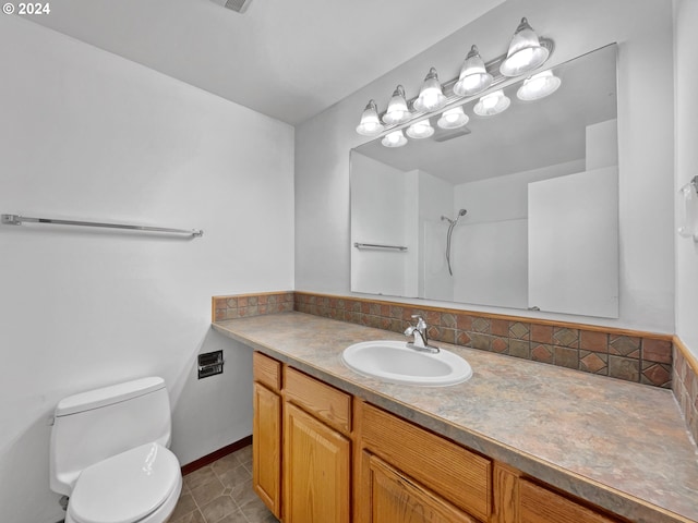 bathroom with vanity, tile patterned floors, toilet, and walk in shower