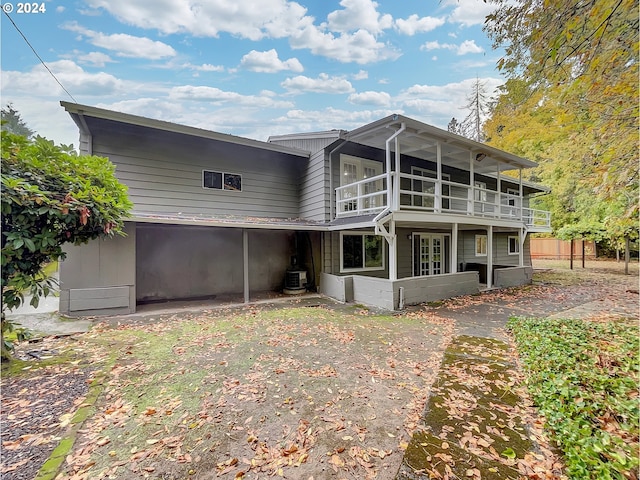 rear view of house with a sunroom, cooling unit, and a patio area