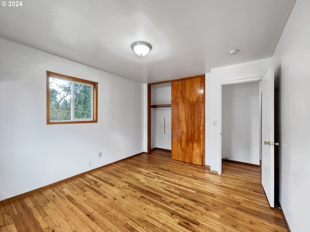 unfurnished bedroom with a closet and light hardwood / wood-style floors