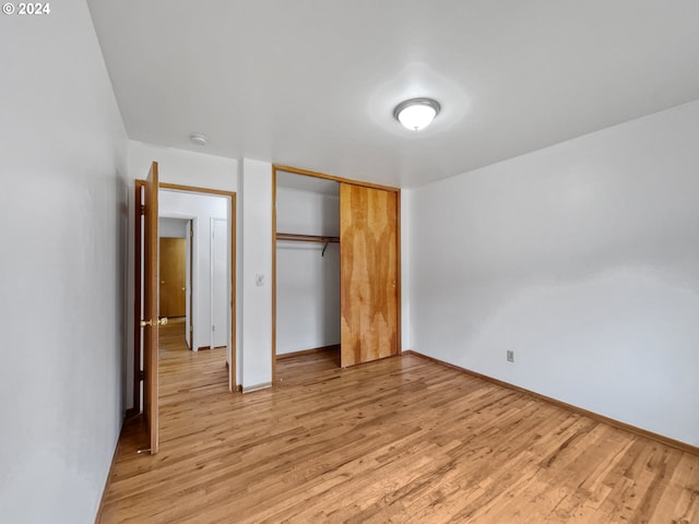 unfurnished bedroom with a closet and light hardwood / wood-style flooring