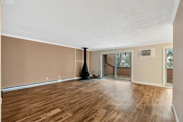 unfurnished living room with a wood stove, a wealth of natural light, hardwood / wood-style floors, and a wall mounted AC