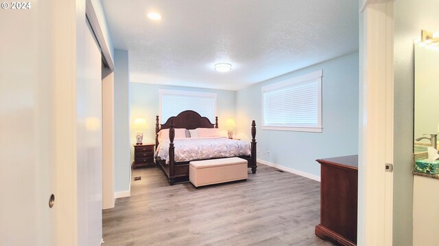 bedroom featuring a textured ceiling and light hardwood / wood-style flooring