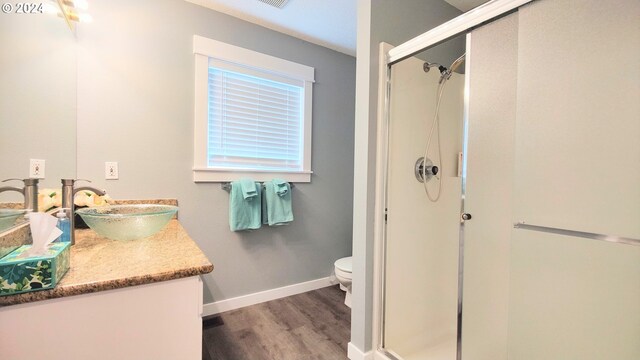 bathroom with walk in shower, toilet, vanity, and hardwood / wood-style flooring