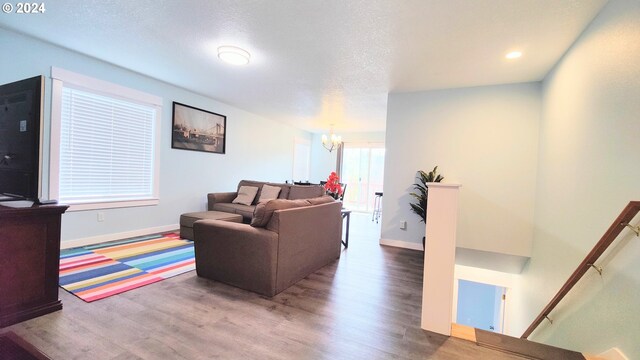 living room featuring hardwood / wood-style floors, a textured ceiling, and a chandelier