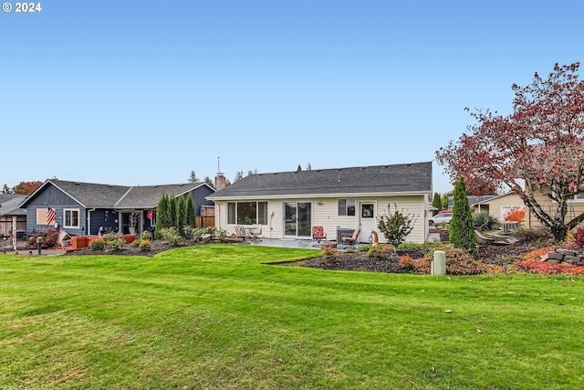 rear view of house featuring a lawn and a patio area