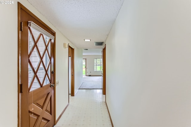 hallway with a textured ceiling