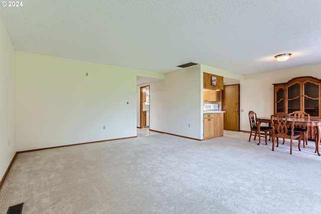 carpeted dining space featuring a textured ceiling