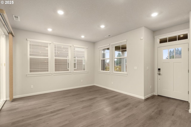 entrance foyer with dark hardwood / wood-style floors and a textured ceiling