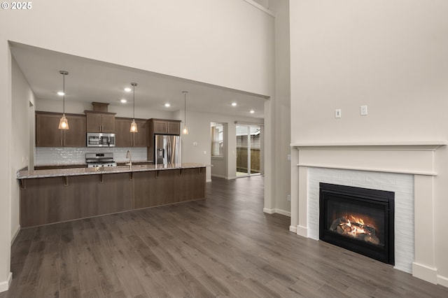 kitchen featuring appliances with stainless steel finishes, a kitchen breakfast bar, kitchen peninsula, and hanging light fixtures