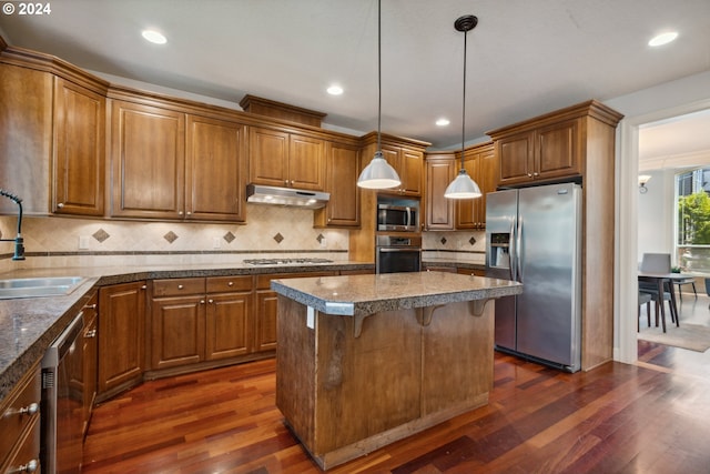 kitchen featuring a kitchen island, dark hardwood / wood-style floors, pendant lighting, sink, and stainless steel appliances