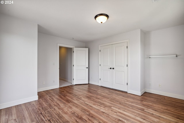 unfurnished bedroom featuring a closet and light wood-type flooring