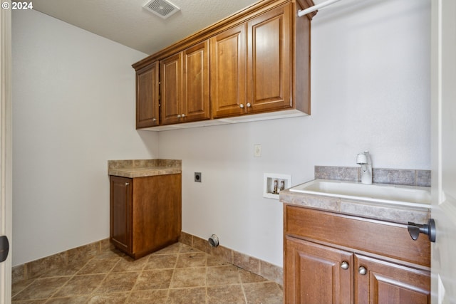 laundry area featuring sink, cabinets, a textured ceiling, electric dryer hookup, and washer hookup