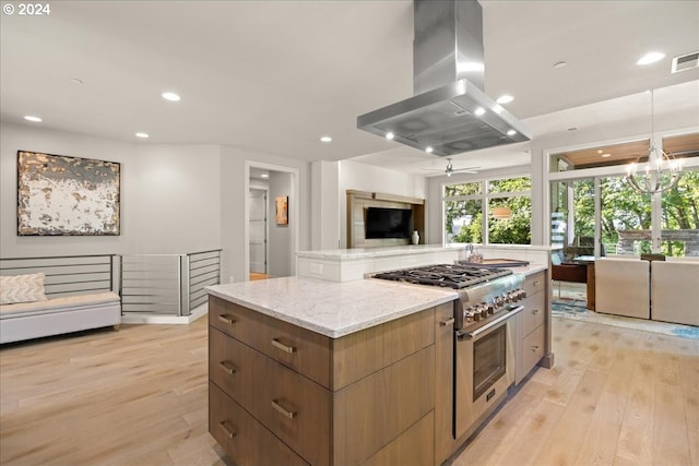 kitchen featuring light hardwood / wood-style flooring, high end stainless steel range oven, light stone countertops, island exhaust hood, and a kitchen island