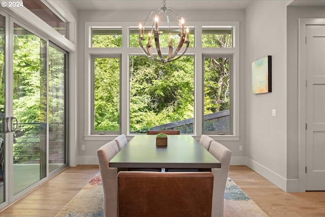 dining area with a wealth of natural light, light wood-type flooring, and a chandelier