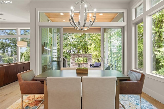 sunroom / solarium featuring a wealth of natural light, an inviting chandelier, and wooden ceiling