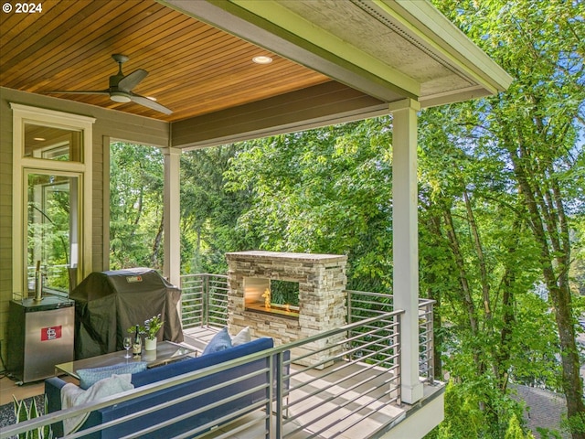 view of patio / terrace featuring an outdoor living space with a fireplace, area for grilling, and a ceiling fan