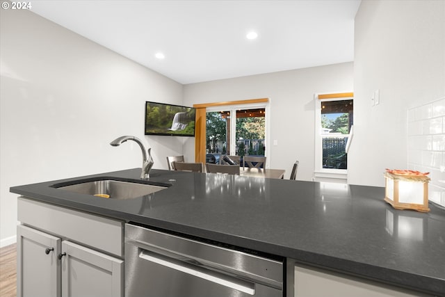 kitchen featuring light hardwood / wood-style flooring, sink, dishwasher, white cabinets, and lofted ceiling