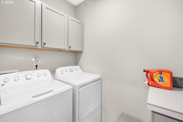 laundry room featuring independent washer and dryer and cabinets