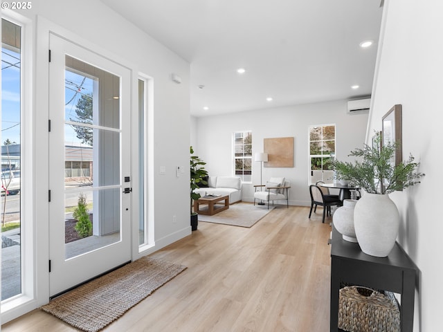 entryway featuring light wood-type flooring and an AC wall unit